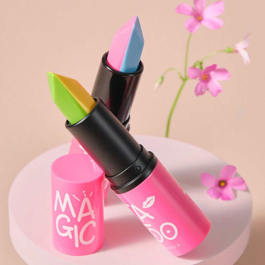 Pink lipstick with colorful applicator on a beige background with flowers